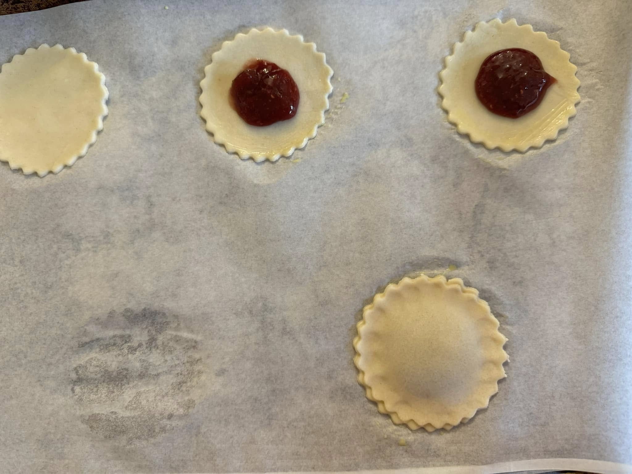 Heart-shaped pie crust pieces with strawberry jam filling in center]