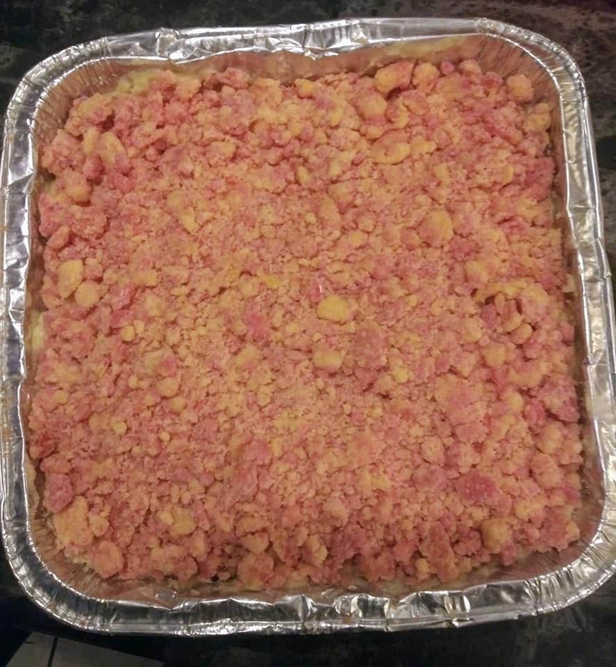 Strawberry Crunch Crumble Cheesecake set and ready to slice in a foil pan