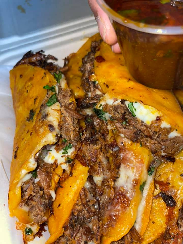 Golden birria tacos served with a side of rich red consome for dipping