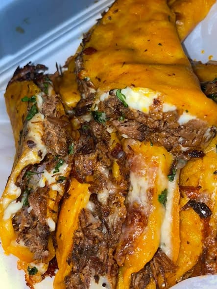 Golden birria tacos served with a side of rich red consome for dipping