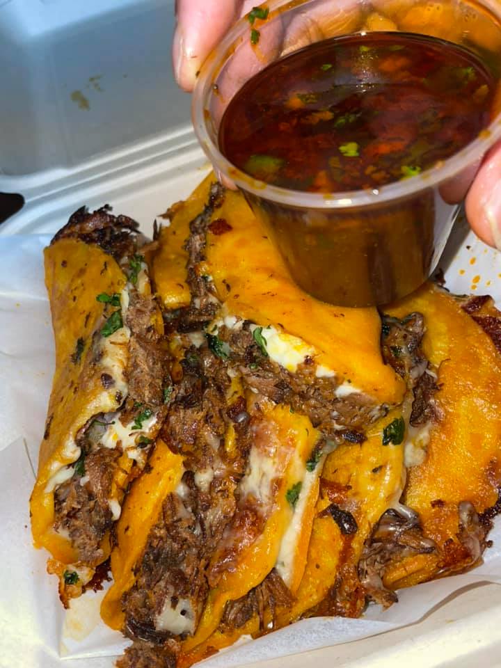 Golden birria tacos served with a side of rich red consome for dipping