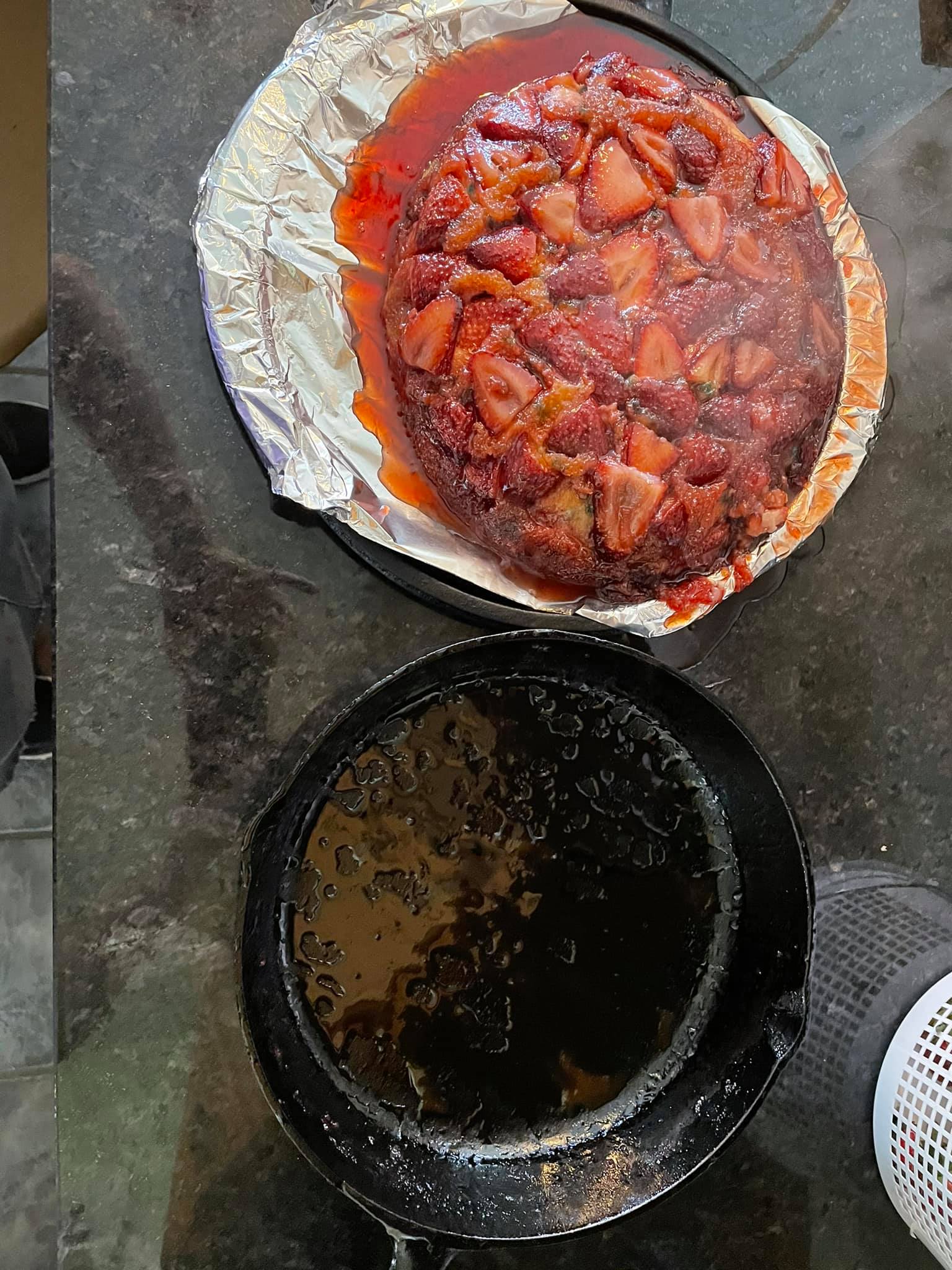 A fresh strawberry upside-down cake just after flipping, with bright red strawberry glaze dripping down