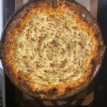 fully baked cottage pie in cast iron skillet with golden brown potato top