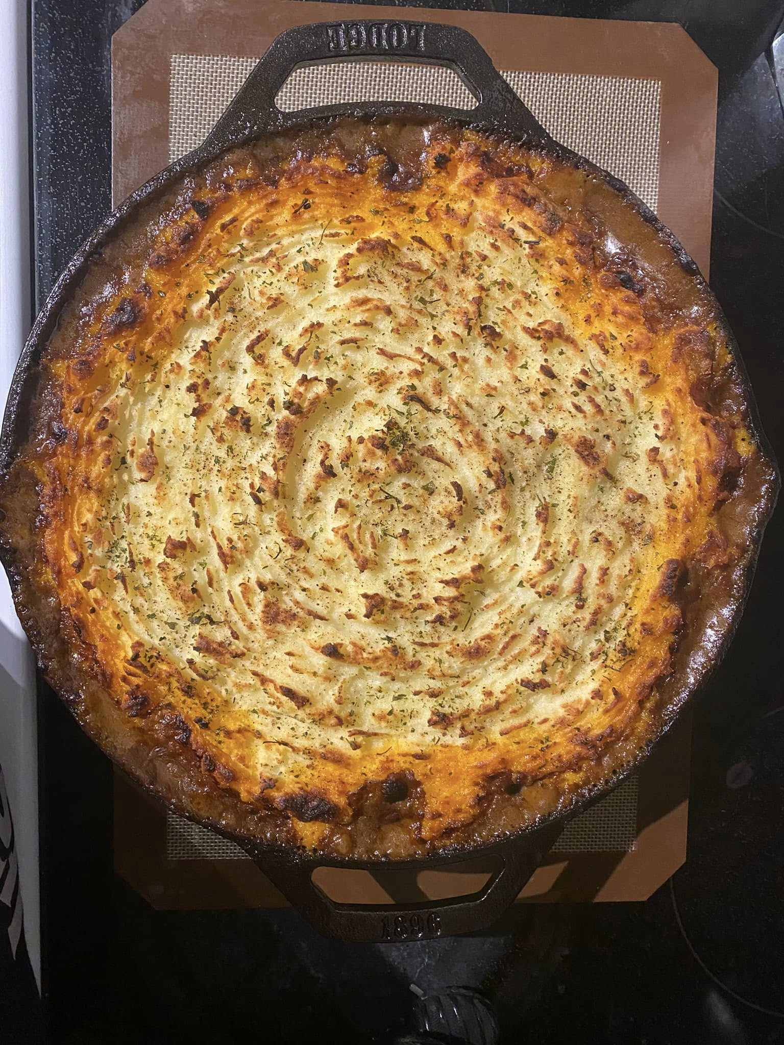fully baked cottage pie in cast iron skillet with golden brown potato top