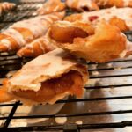 glazed fried hand pie broken open showing blackberry filling inside