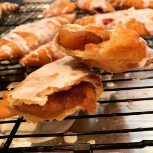 glazed fried hand pie broken open showing blackberry filling inside