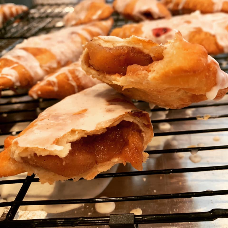 glazed fried hand pie broken open showing blackberry filling inside
