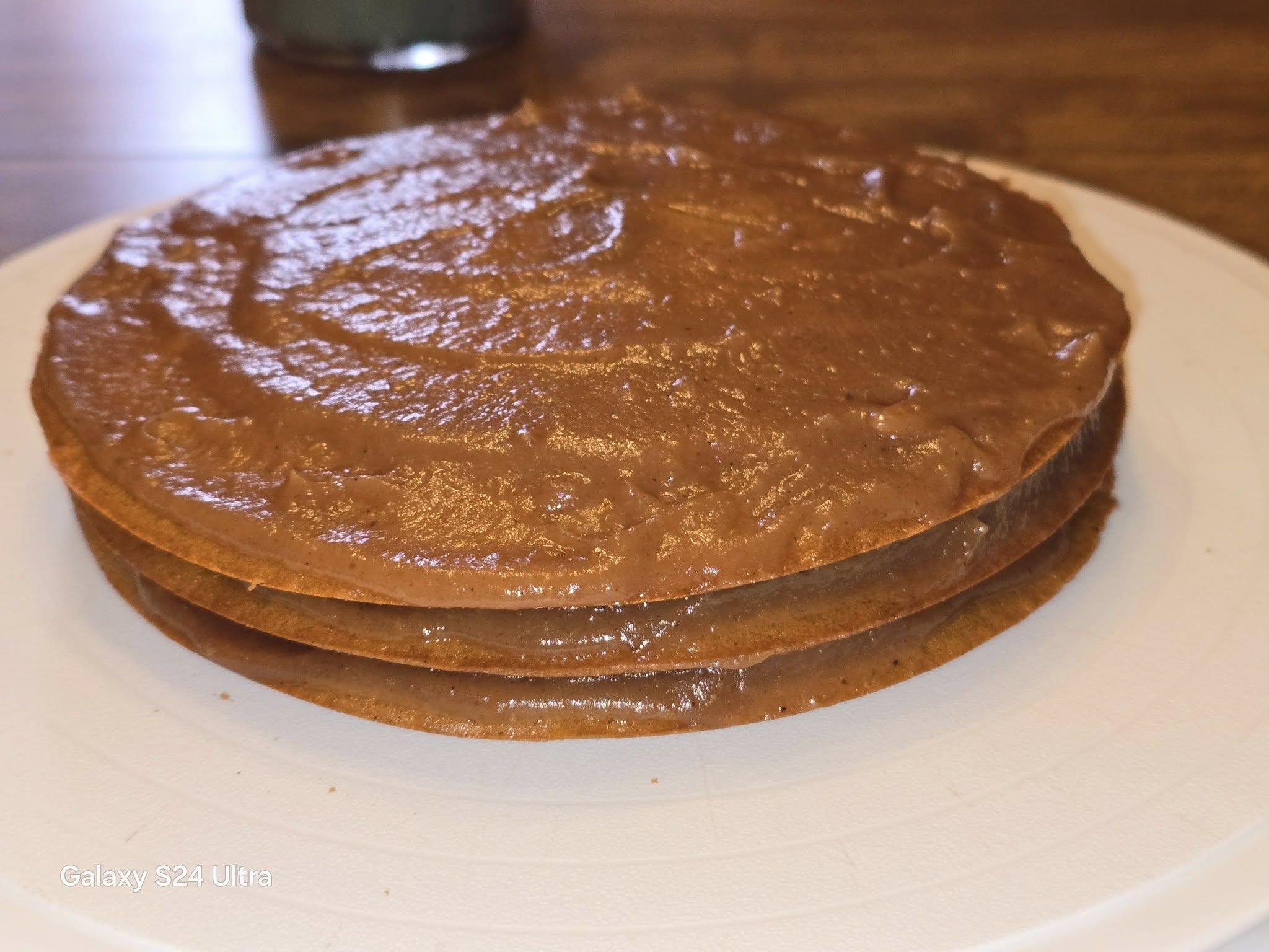 Beginning to stack layers with warm dried apple filling spread between them