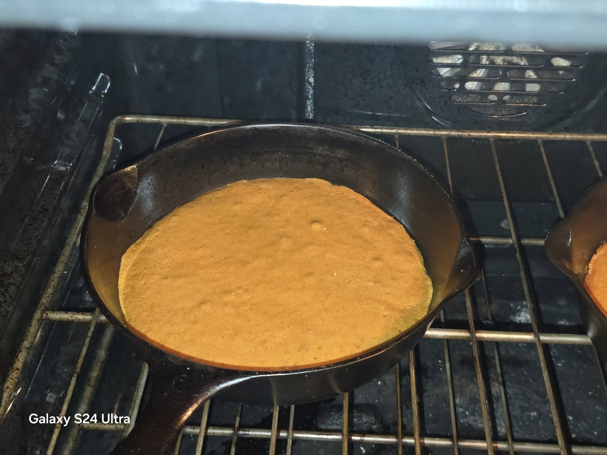 Thin spiced cake layer baking in a cast iron skillet for old fashioned apple stack cake