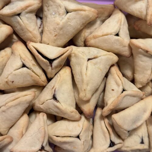 Freshly baked citrus hamantaschen arranged in a container