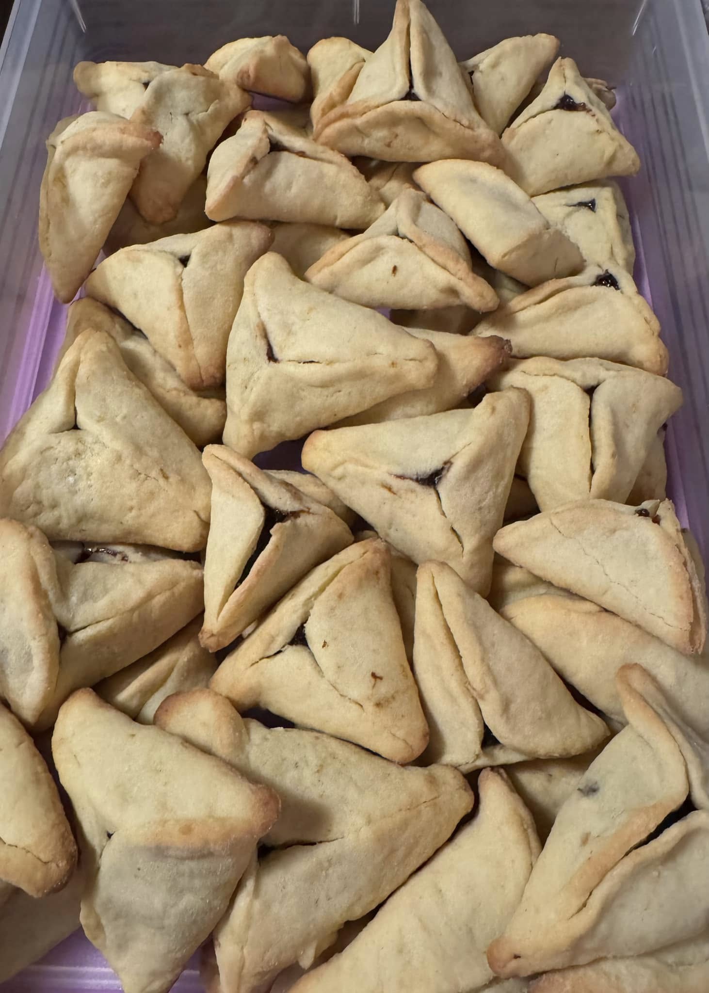 Freshly baked citrus hamantaschen arranged in a container