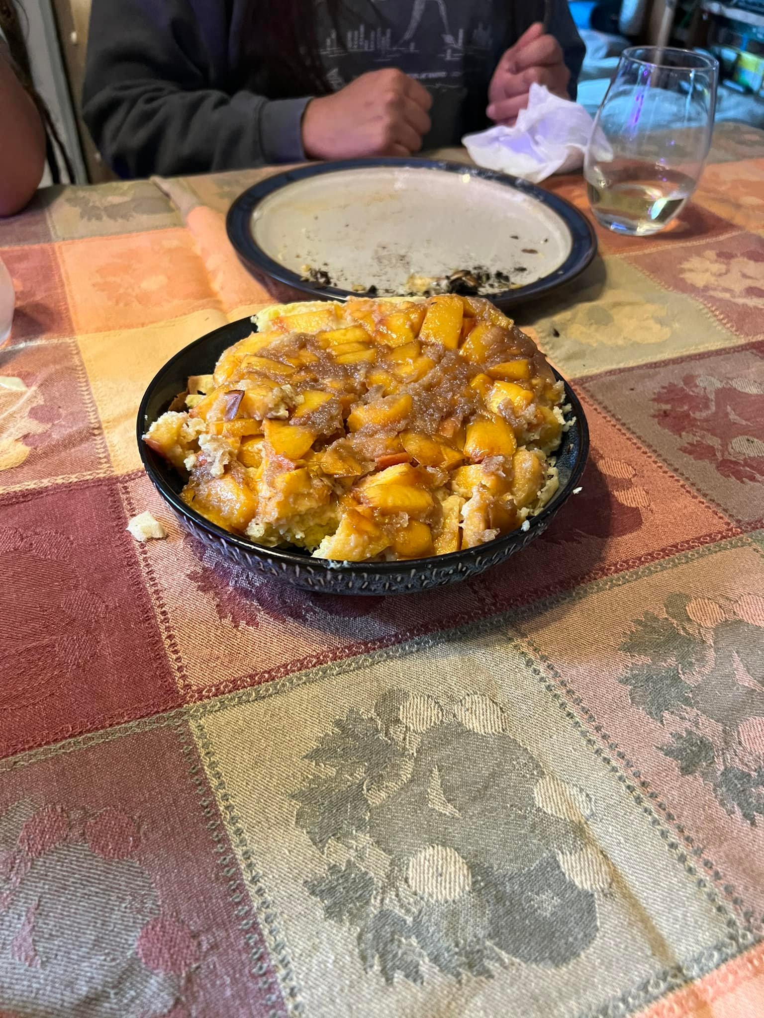 peach upside-down cake served on a plate after camping meal, peaches glistening on top]