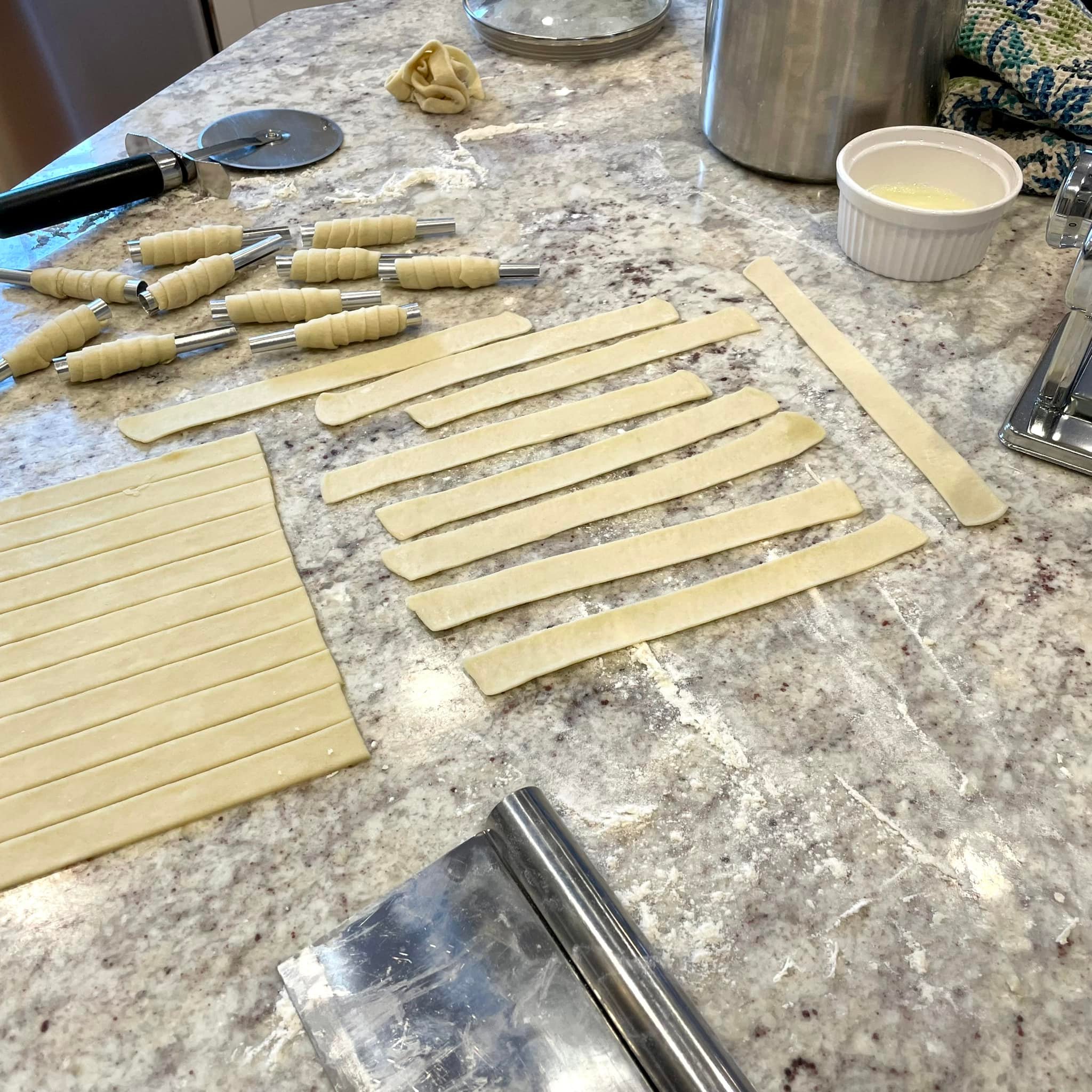 sheet of dough cut into narrow uniform strips using a pizza cutter
