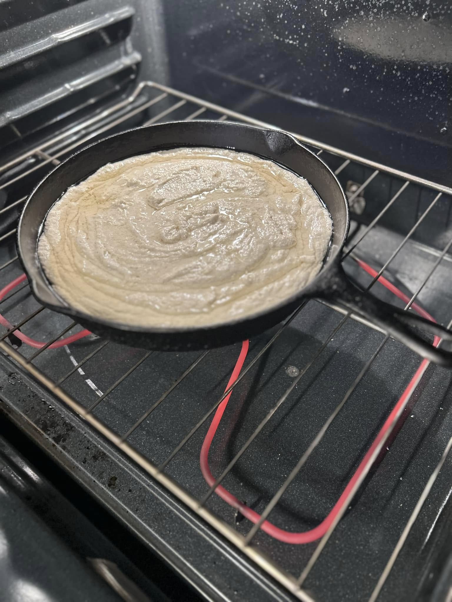 smooth cornbread batter poured into hot cast iron skillet before baking