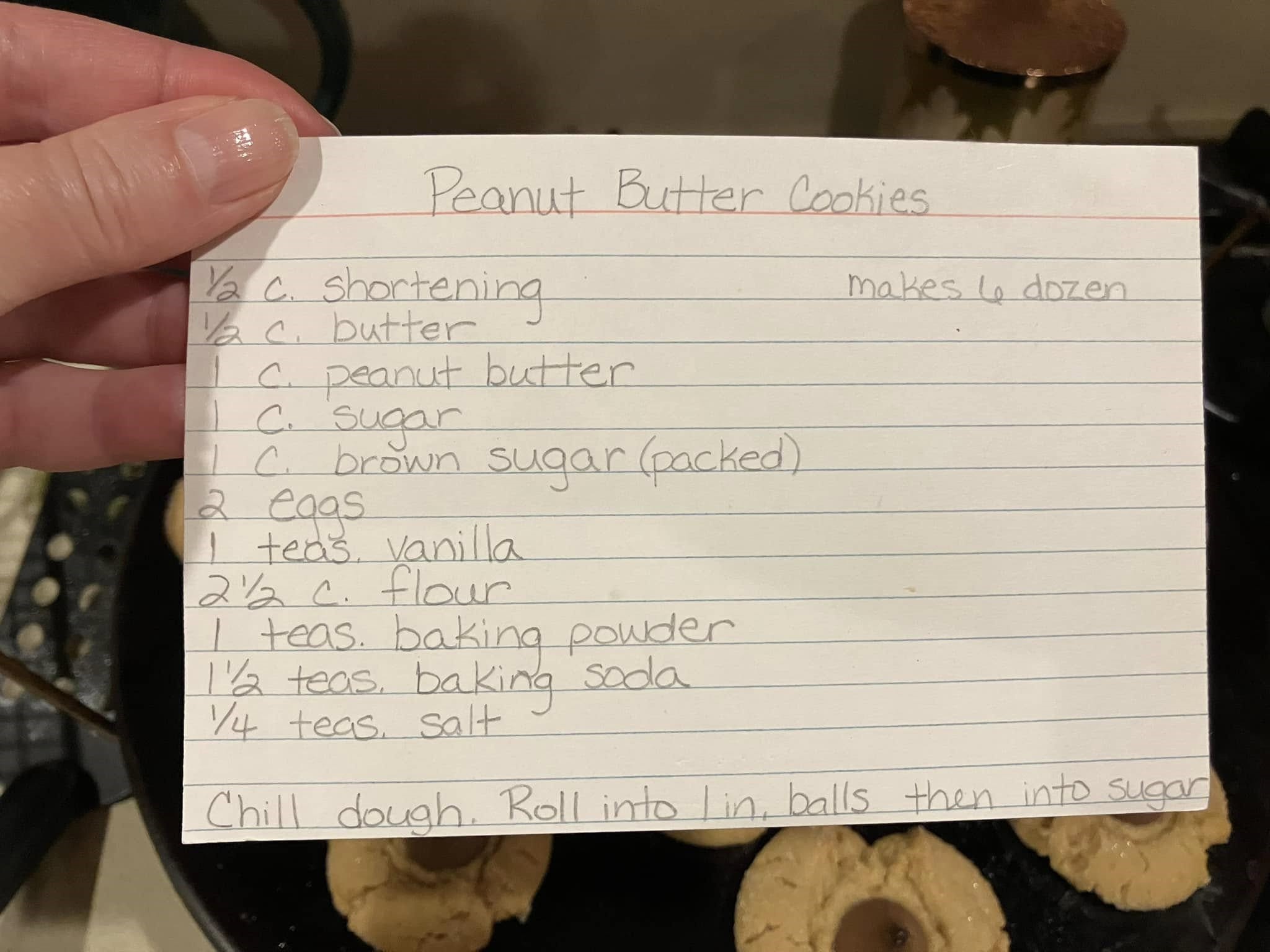 handwritten peanut butter cookie recipe on index card with ingredients and instructions