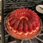 vintage cranberry raspberry jello mold with cream cheese base on glass platter