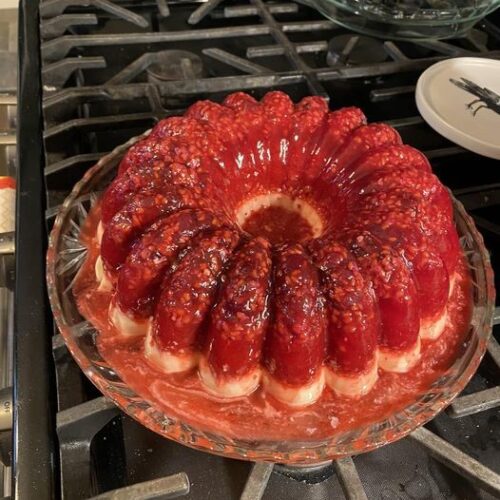 vintage cranberry raspberry jello mold with cream cheese base on glass platter