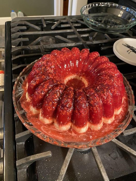 vintage cranberry raspberry jello mold with cream cheese base on glass platter