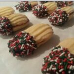 Finished Jelly Stick cookies cooling on foil, showing the chocolate dipped ends.