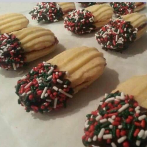 Finished Jelly Stick cookies cooling on foil, showing the chocolate dipped ends.