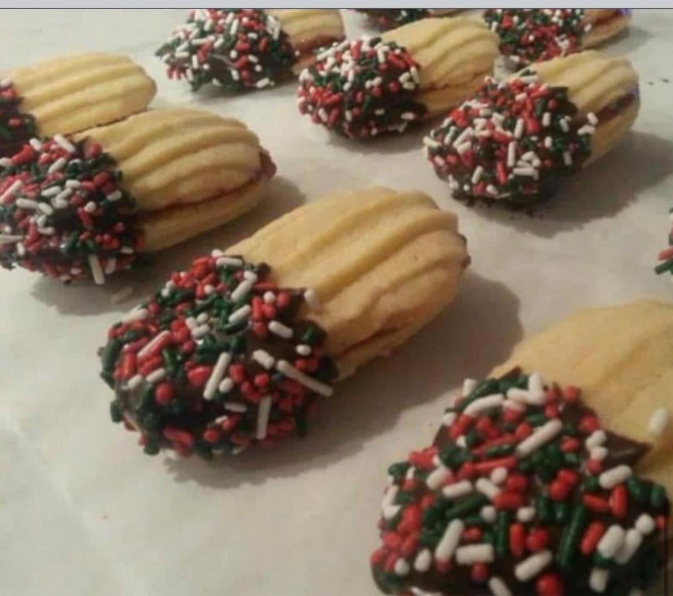 Finished Jelly Stick cookies cooling on foil, showing the chocolate dipped ends.