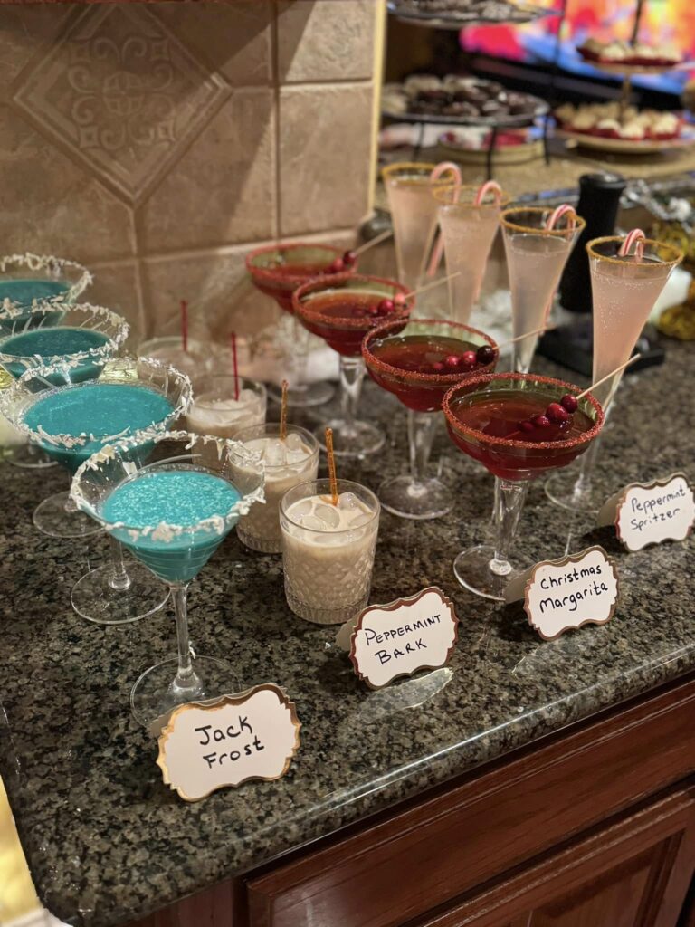Tiered Christmas dessert stand filled with chocolate bark, dipped cookies, and strawberries with cream at a holiday party