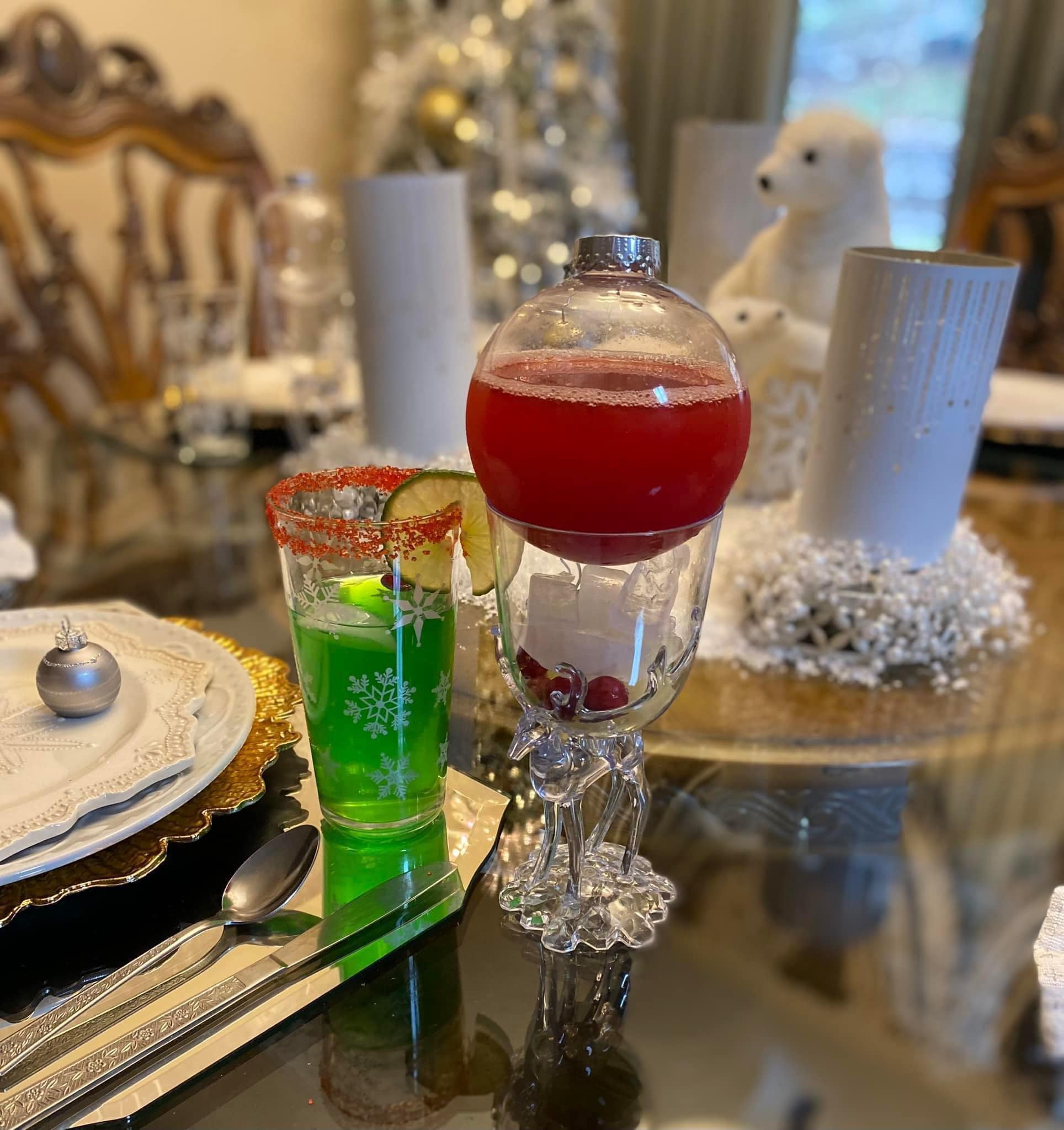 Green cornflake wreath cookies with red cinnamon candies displayed on a cake stand next to a Santa Claus figure