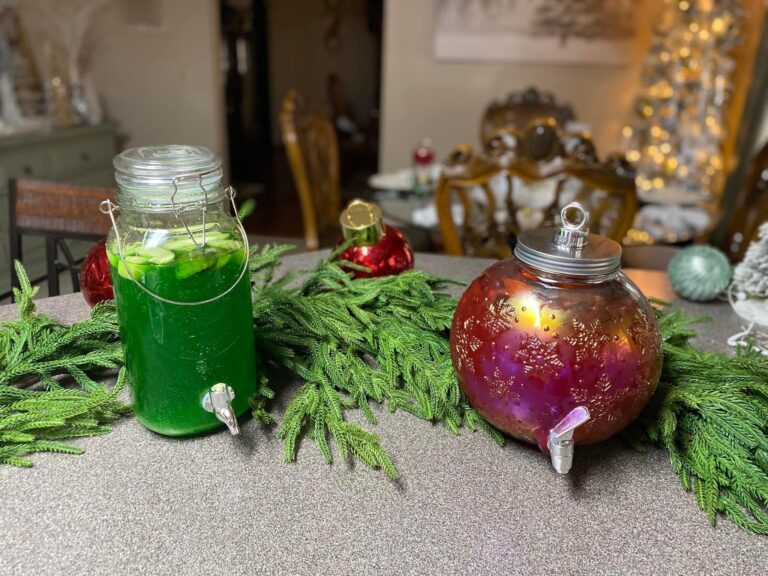 A three-tiered dessert stand filled with white chocolate dipped cookies, chocolate bark, and strawberries filled with cream at a Christmas party.