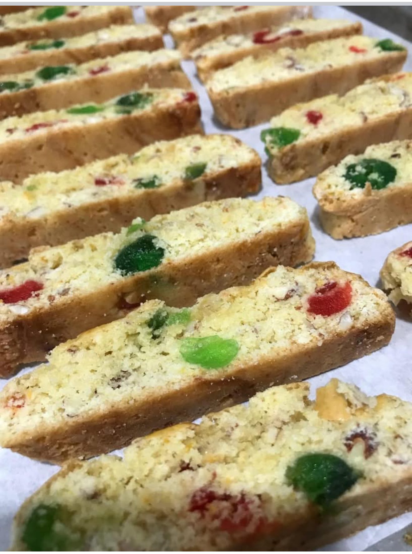 Close up texture shot of sliced biscotti showing the almonds and chopped cherries inside