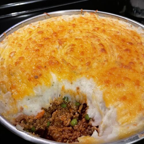 Golden brown cheesy mashed potato topping on a savory beef and vegetable cottage pie.