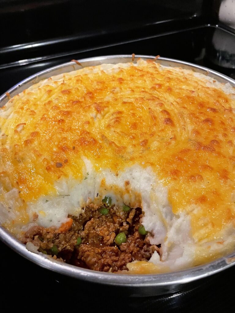 Golden brown cheesy mashed potato topping on a savory beef and vegetable cottage pie.