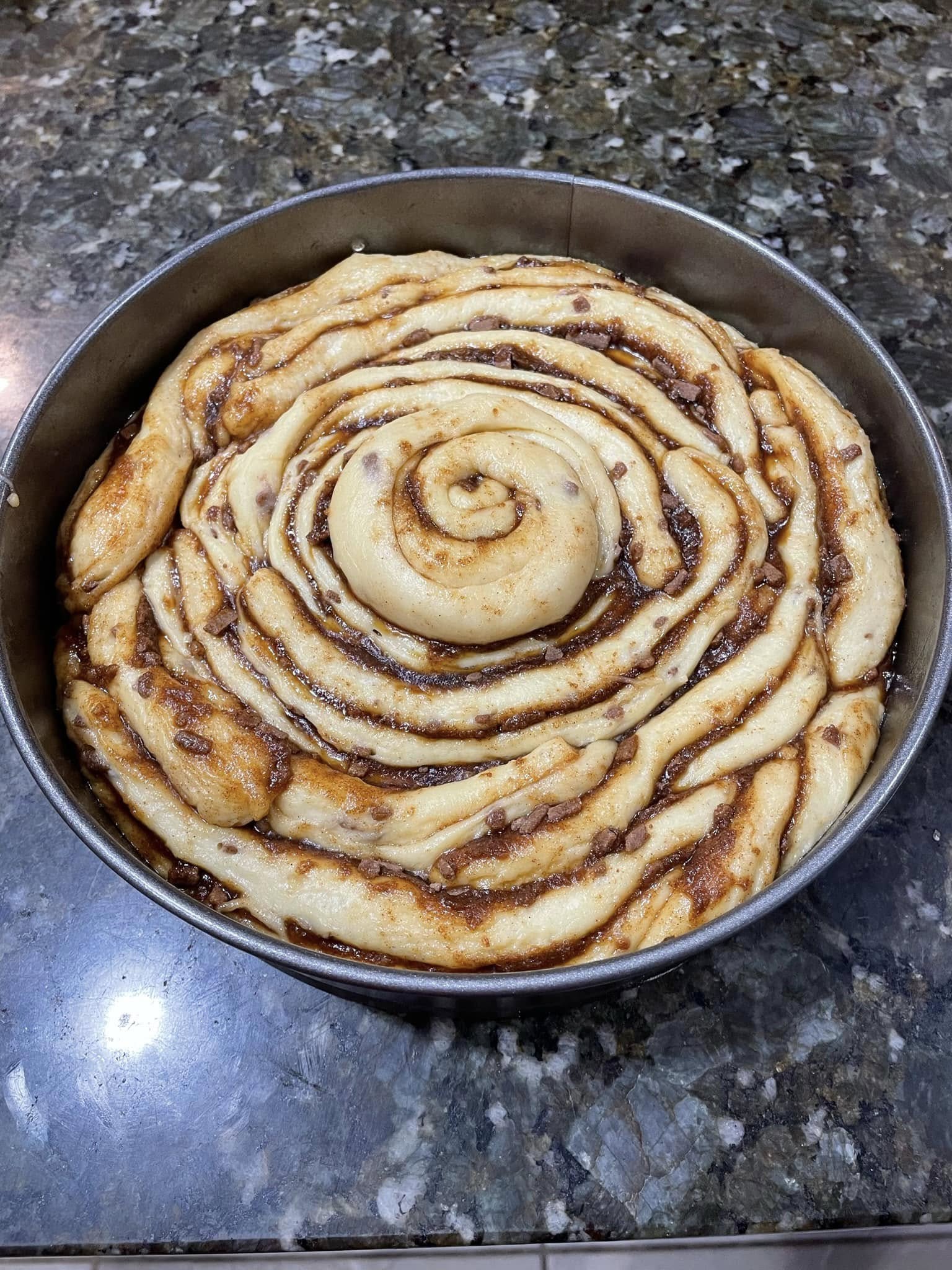 A recipe page for a Giant Cinnamon Roll showing a close-up of a glazed slice on a fork, alongside the ingredient list and baking instructions.