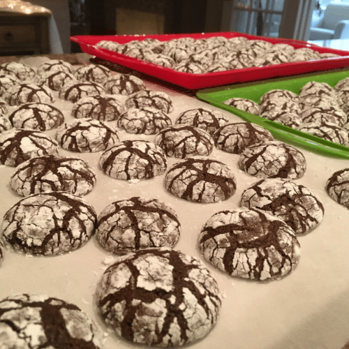 A stack of freshly baked chocolate brownie mix crinkle cookies coated in powdered sugar