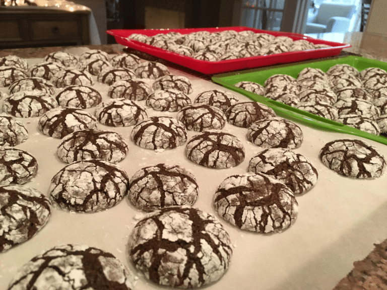 A stack of freshly baked chocolate brownie mix crinkle cookies coated in powdered sugar